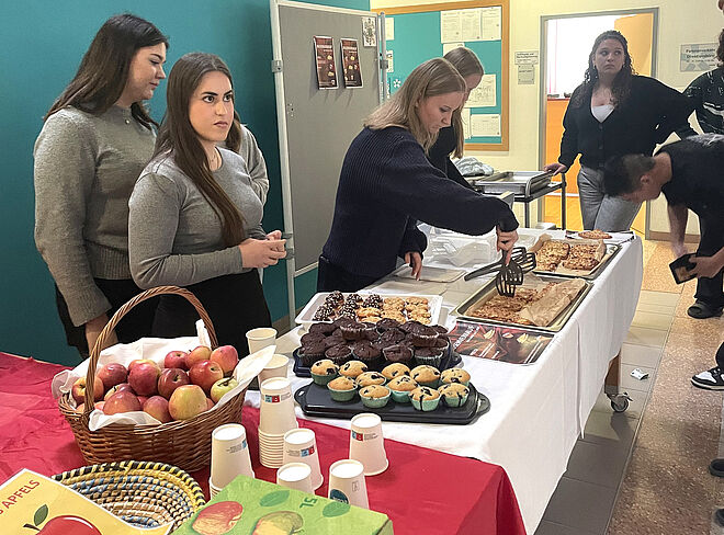 Schülerinnen verkaufen in der großen Pause Apfelprodukte