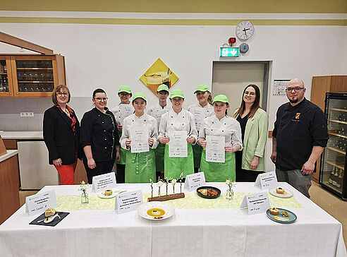 Direktorin mit Schülerinnen und Prüfer vor Buffet