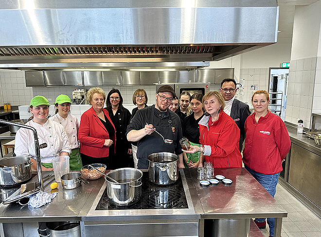 Volkshilfe in der Küche mit Koch