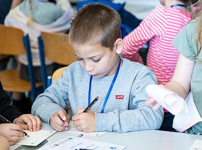 Schüler füllt Zettel aus