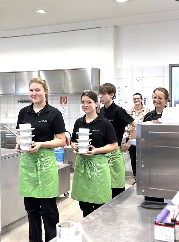 Schüler tragen Suppenschüsslen zum Buffet