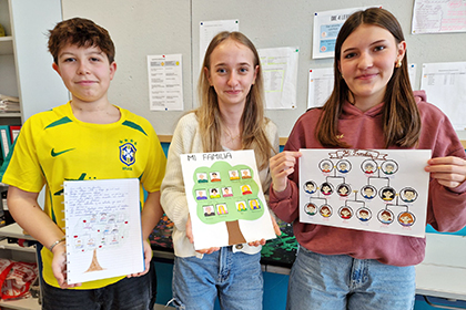 Schüler:innen halten Zettel mit Familienstammbaum