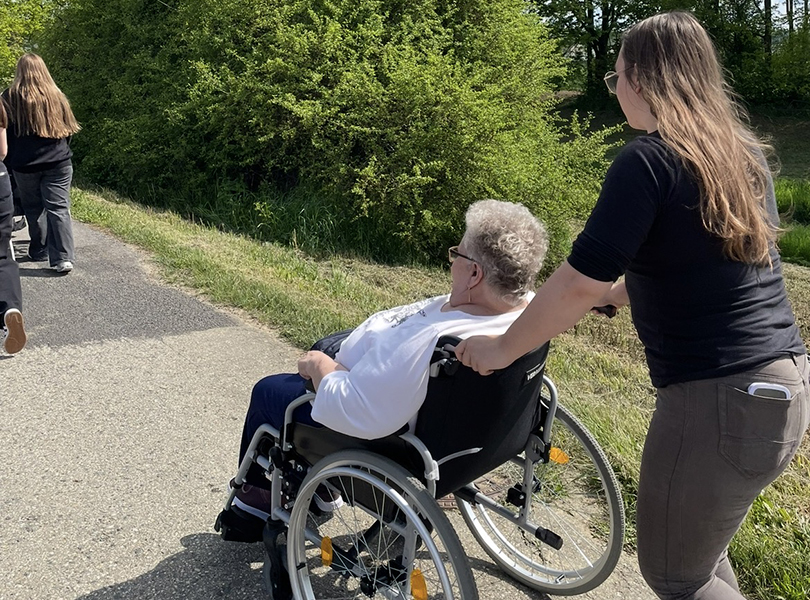 Schülerin schiebt Rollstuhlfahrerin