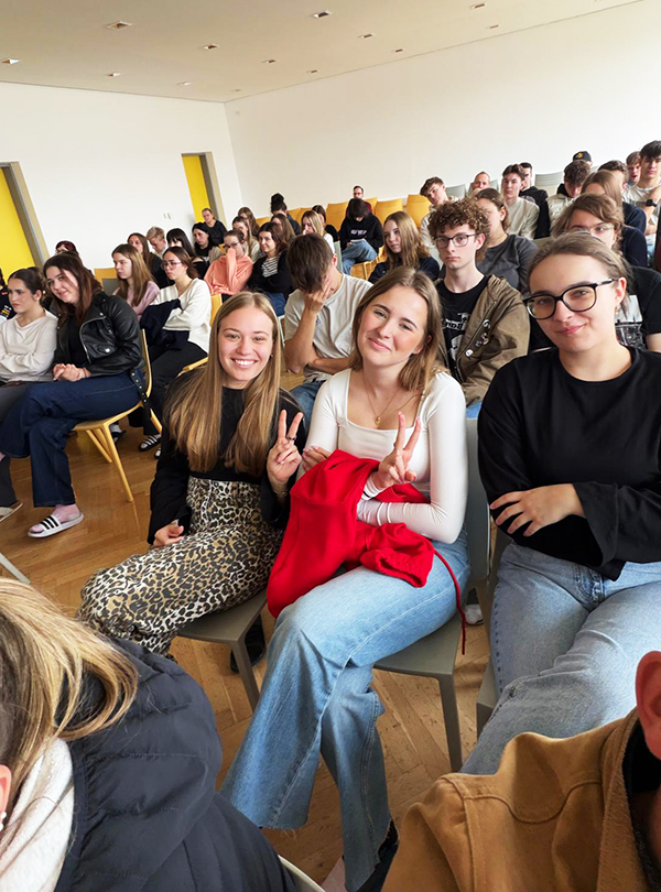 zwei Schülerinnen im Publikum lächeln in die Kamera