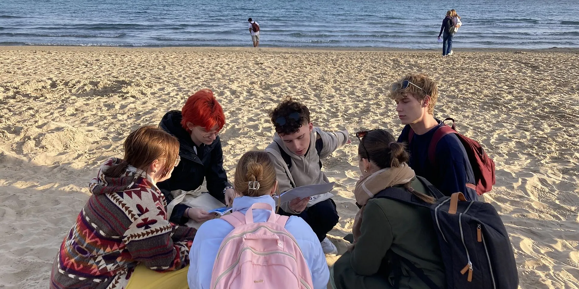 Schülergruppe am Strand im Abendlicht