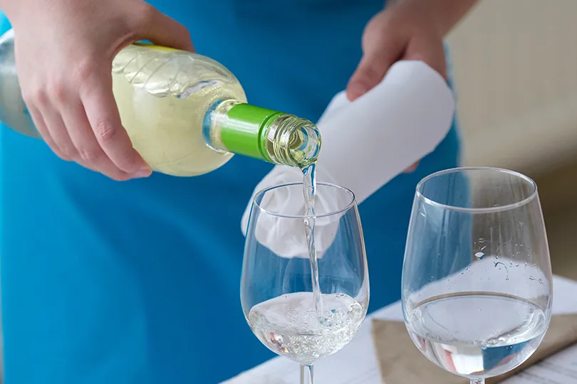 Wein wird beim Service in ein Glas eingeschenkt