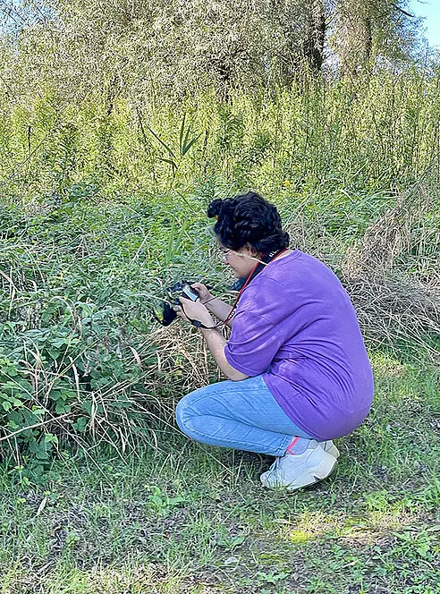 Schülerin fotografiert Gebüsch