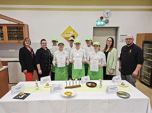 Direktorin mit Schülerinnen und Prüfer vor Buffet