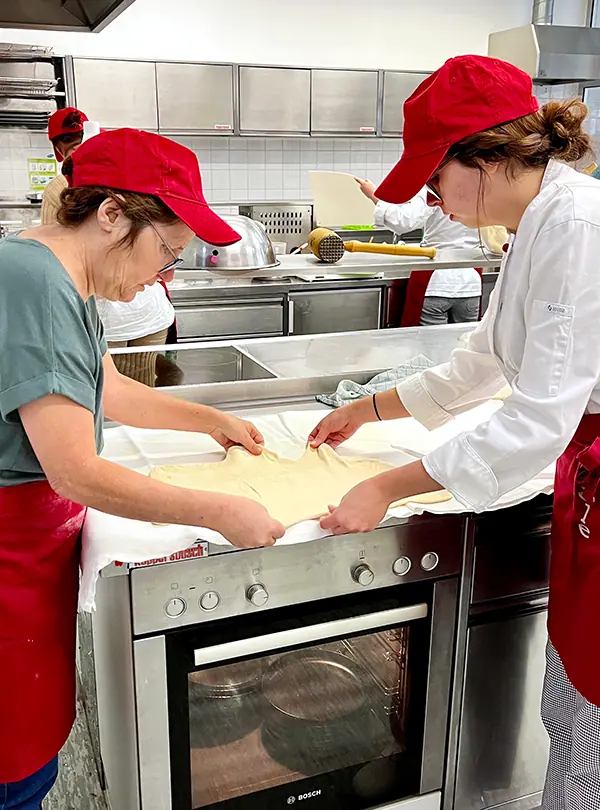 Strudelteig wird zu Zweit ausgezogen