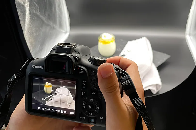 Hände halten eine Kamera, im Display ein Produktfoto