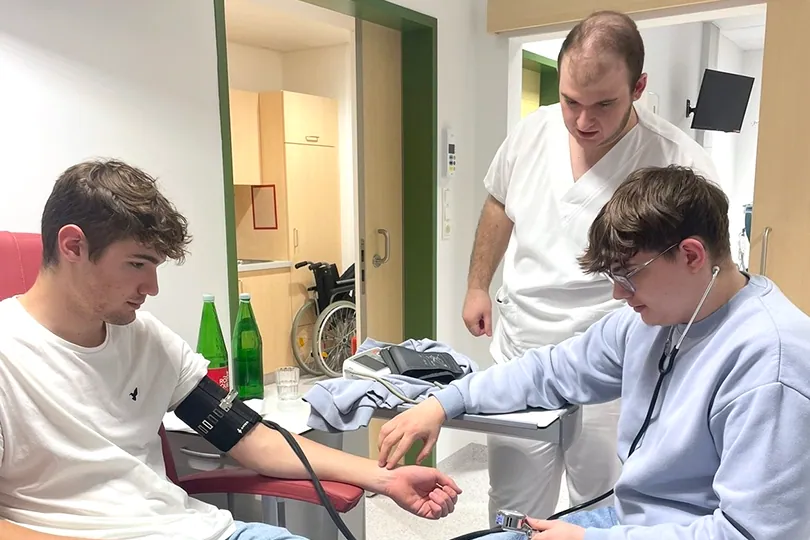 Schüler misst einem Mitschüler den Blutdruck